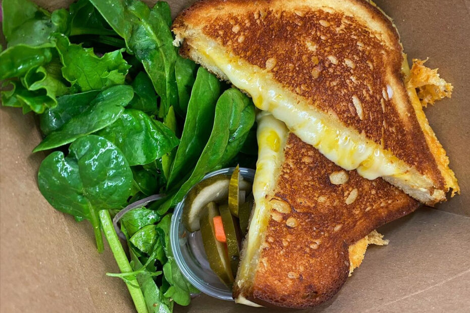 hot grilled cheese sandwich with salad and pickles